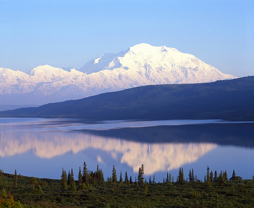 Lumen peittämä vuori ja erämaajärvi Alaskassa.